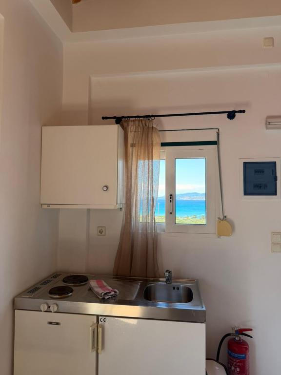 a small kitchen with a sink and a window at Sunset elafonisos in Elafonisos