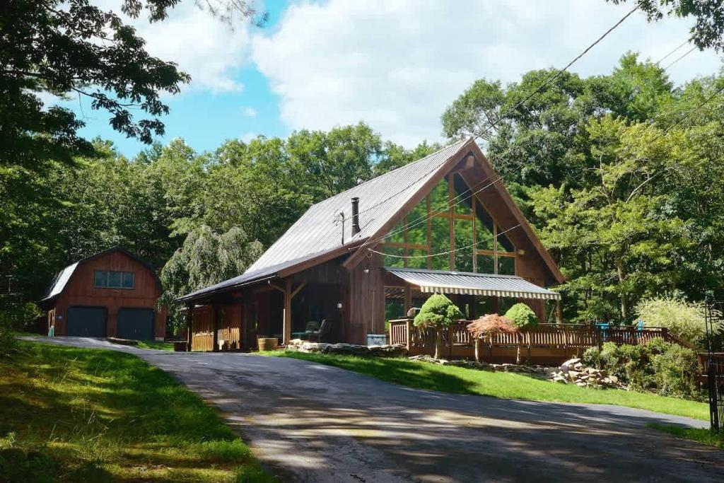 a large wooden barn with a road in front at The Luxury Cabin at Deep Hollow in Narrowsburg