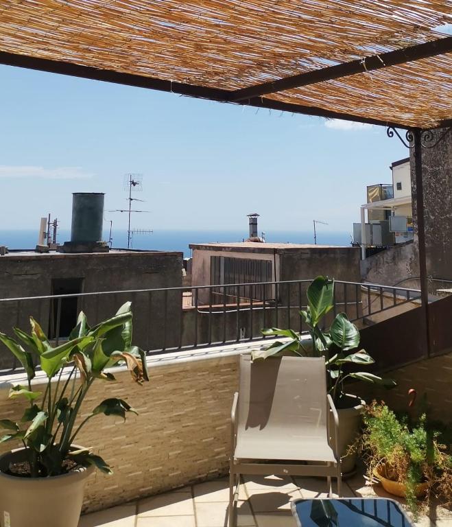 a balcony with a chair and a view of the ocean at Donna Rosa - Main Avenue in Taormina