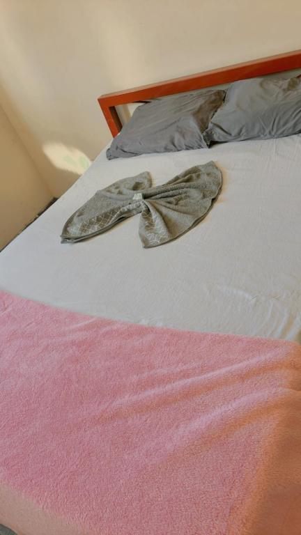a hat on a bed in a room at hotel larena in Sete Lagoas