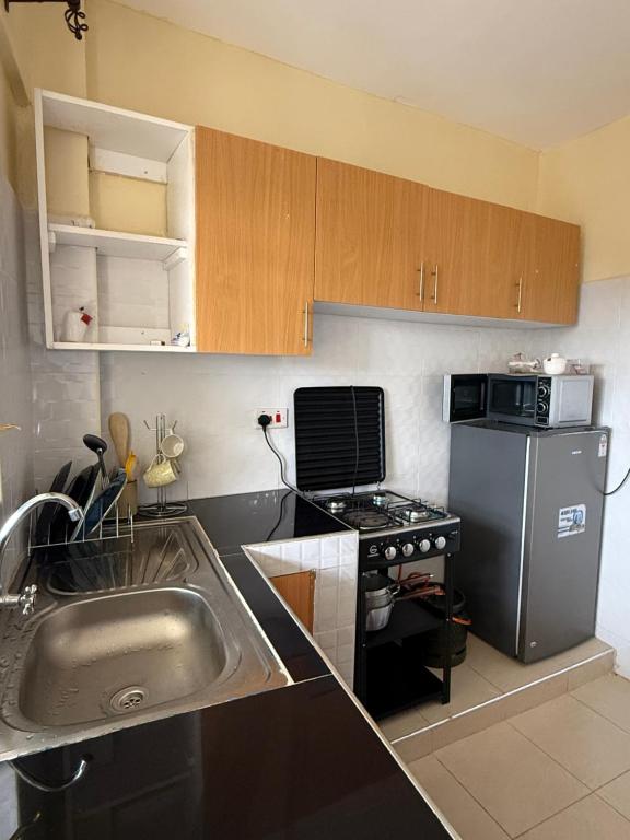 a small kitchen with a sink and a stove at Luxe homes kenol in Kabuku