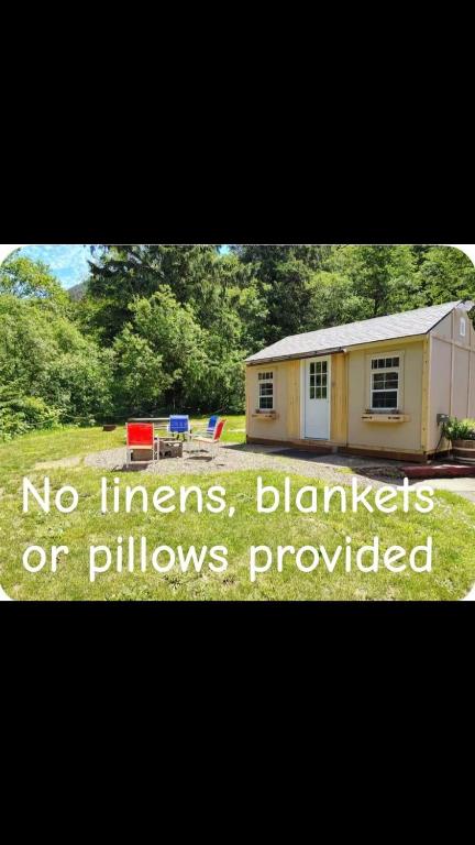 a tiny house with a sign that reads no linens blankets or pillows at Misty River RV Park in Tillamook
