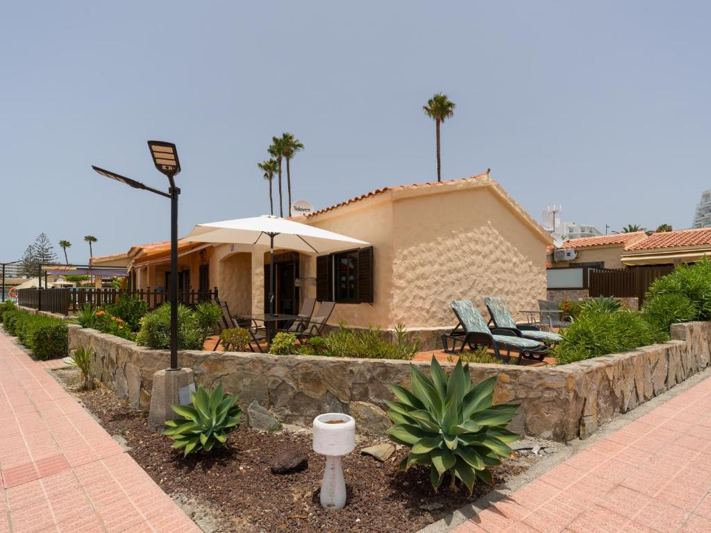 a house with an umbrella and a patio at Sunny Haven I in Maspalomas