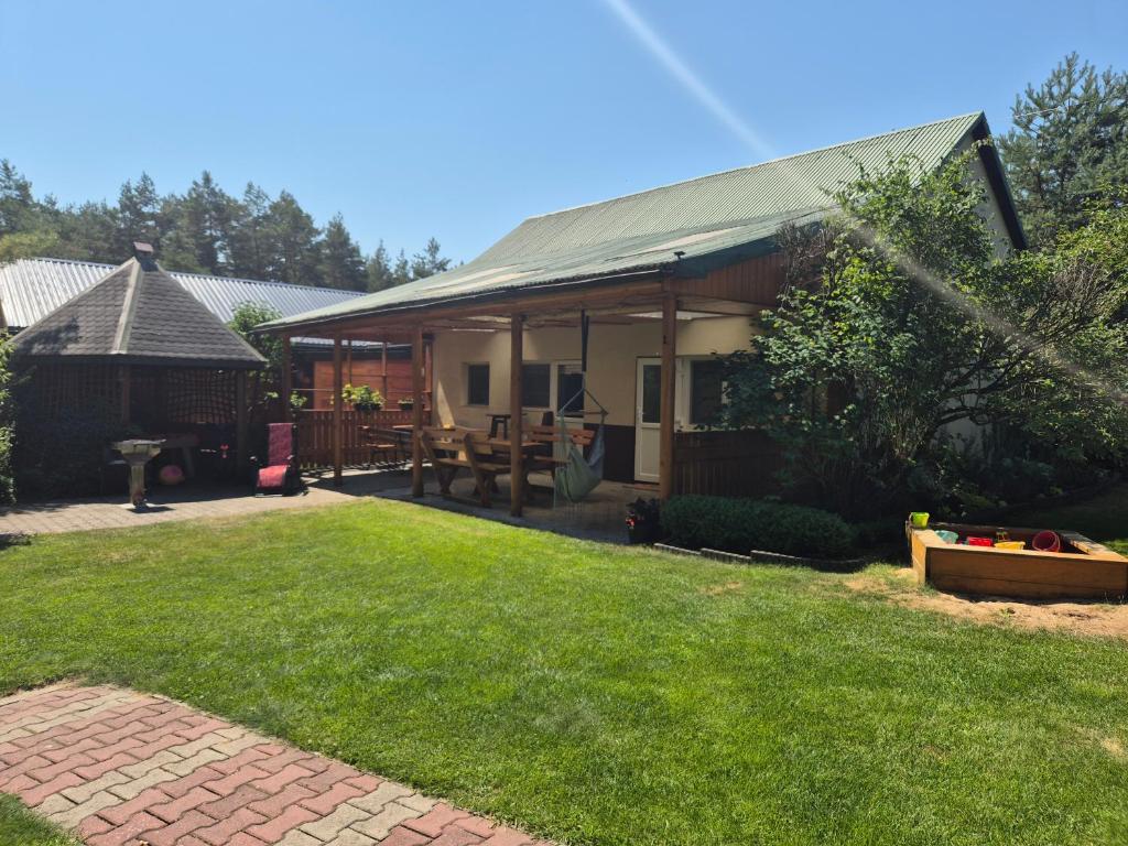 a house with a lawn in front of it at Pod lasem domek letniskowy in Susiec