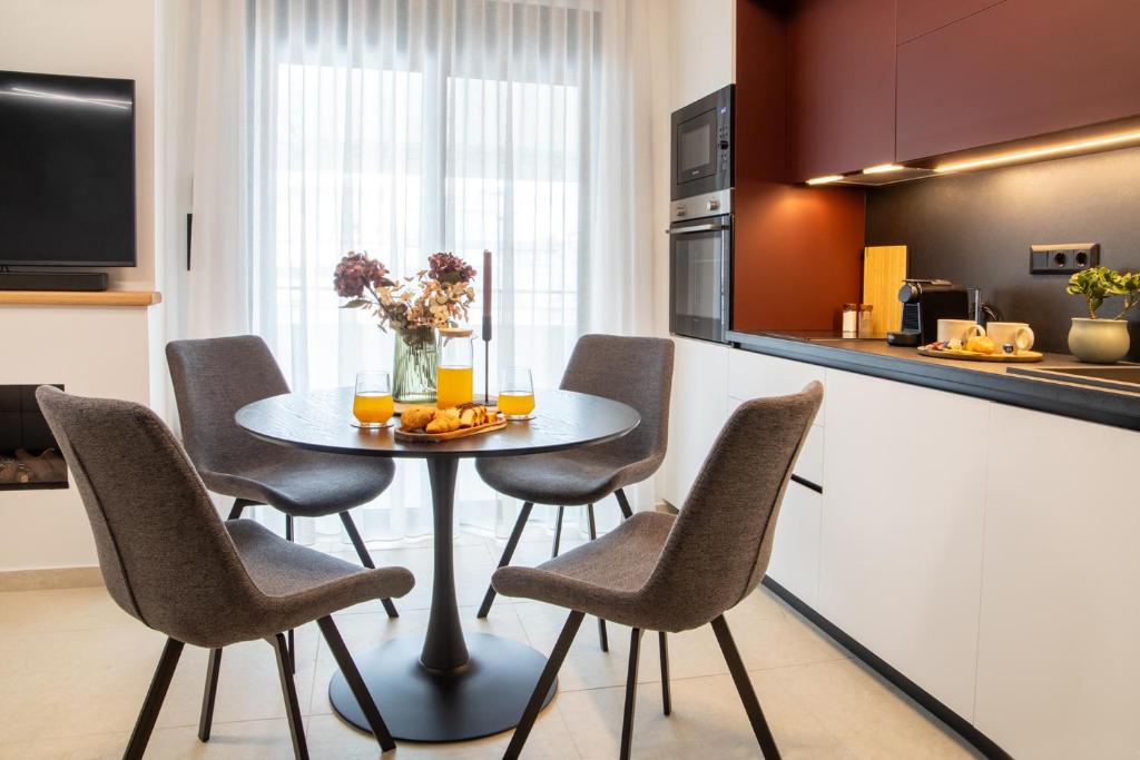 eine Küche und ein Esszimmer mit Tisch und Stühlen in der Unterkunft Mad Spaces in Volos