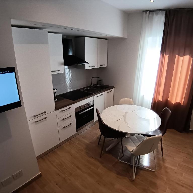a small kitchen with a white table and chairs at Appartamento centro storico in Viverone