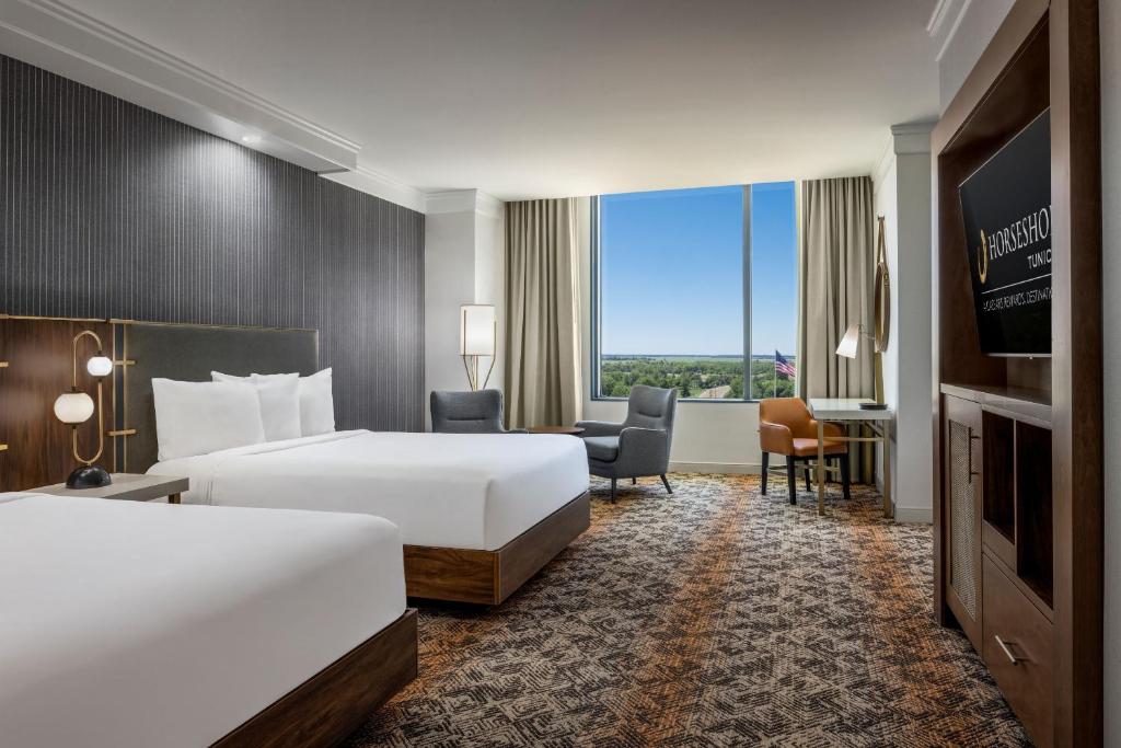 a hotel room with two beds and a flat screen tv at Horseshoe Tunica Hotel & Casino - A Caesars Rewards Destination in Tunica Resorts