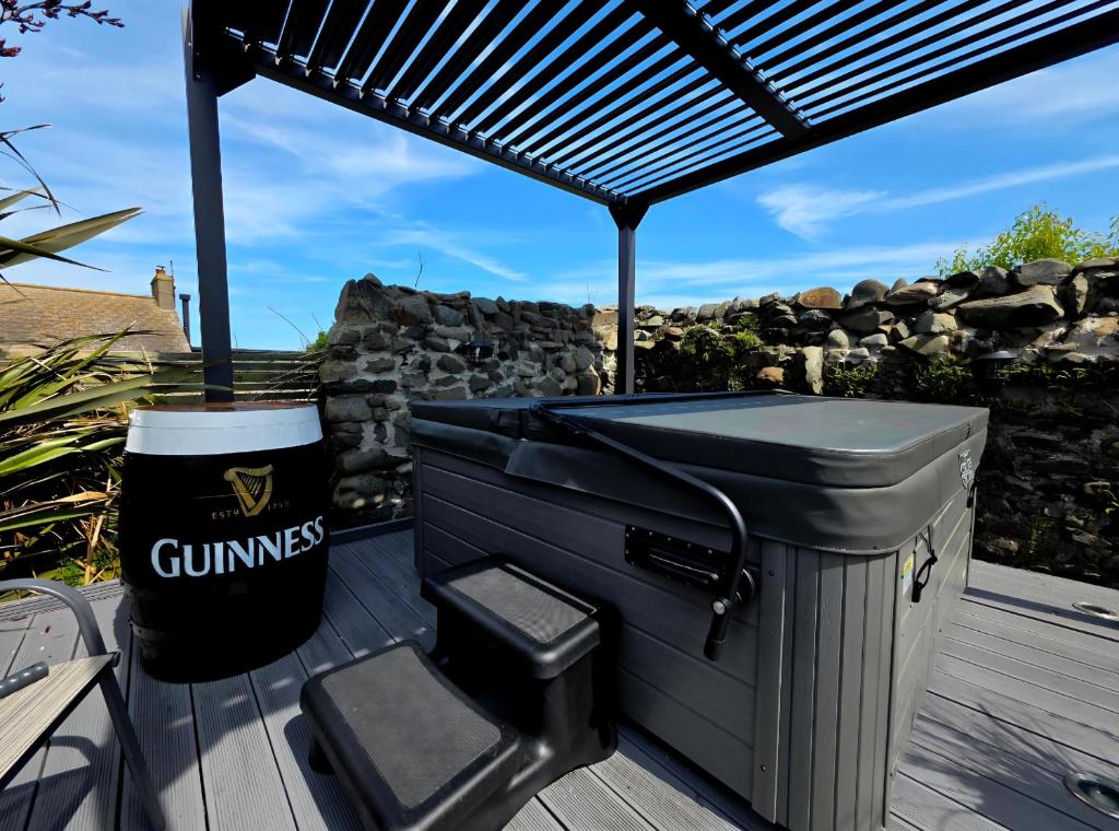 a gimps grill and a trash can on a deck at Butterlump Cottage in Glastry