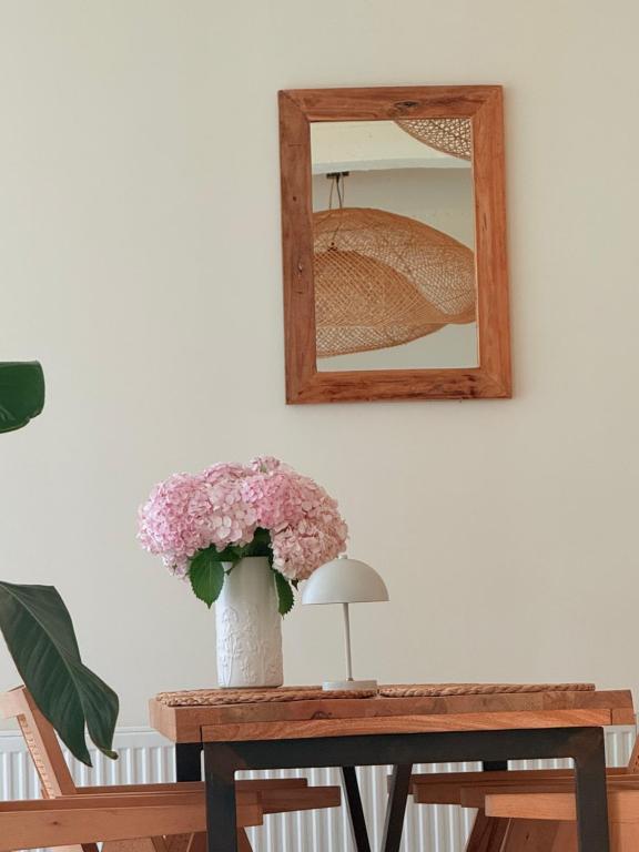 a vase of flowers on a table with a mirror at LIMANI in Grigoleti