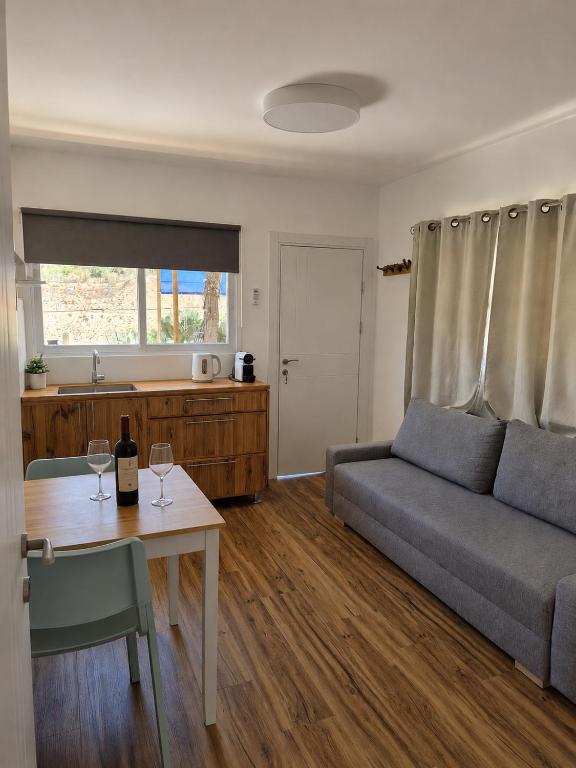 a living room with a couch and a table with wine glasses at Moonlight Suite Arad צימר אור הירח, ערד in Arad