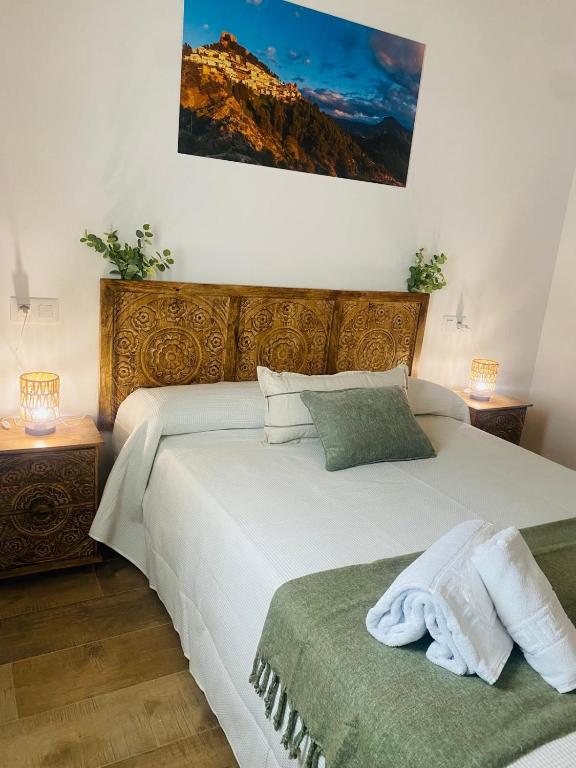a bedroom with two beds and two tables with lamps at Casa El saucar in El Robledo