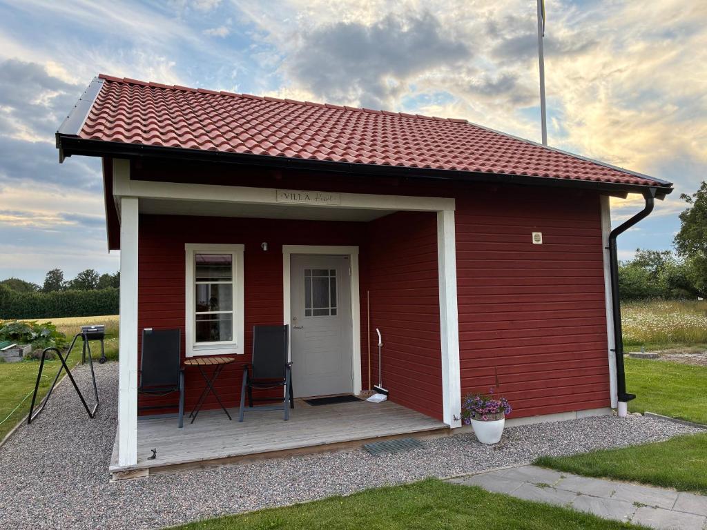 ein roter Schuppen mit zwei Stühlen und einem Tisch in der Unterkunft Hassels hus in Vikingstad