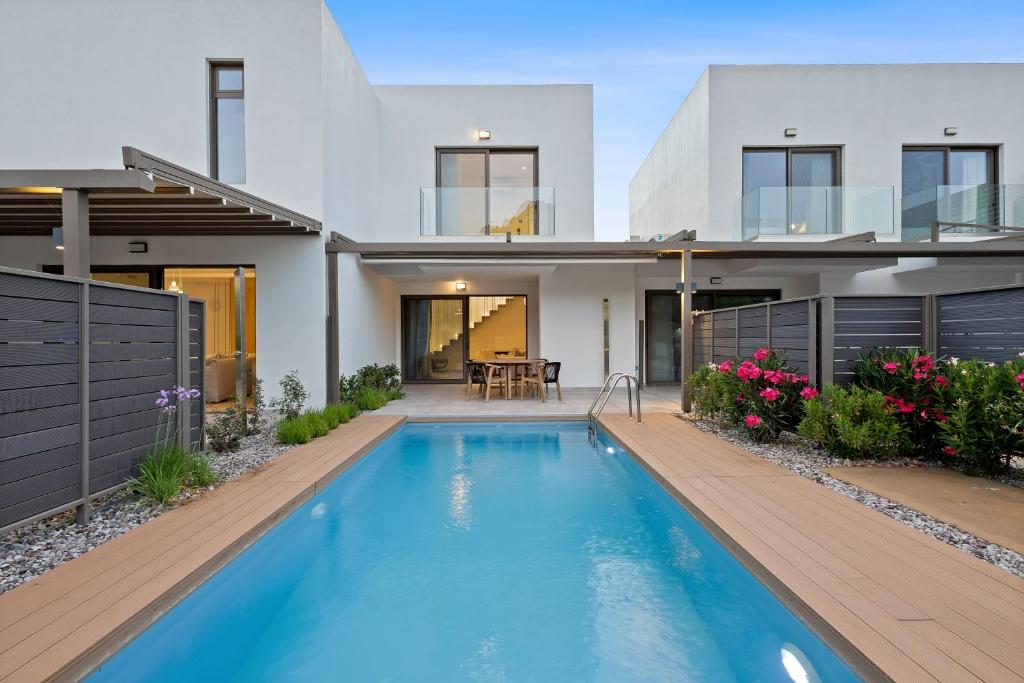 a house with a swimming pool in front of it at Saronia Estate in Galatákion