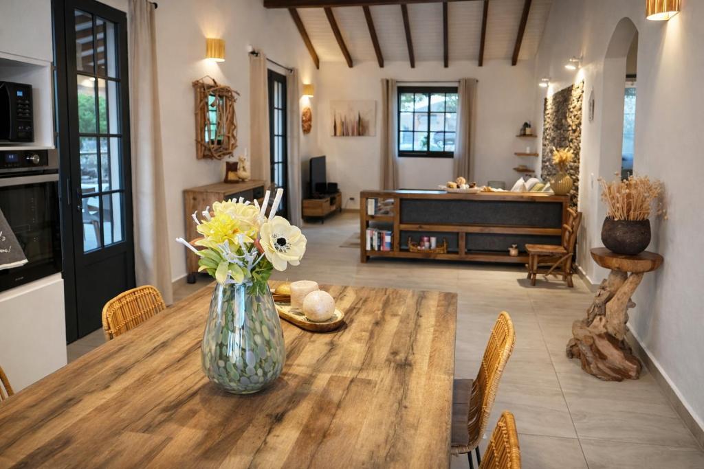 a vase of flowers sitting on a wooden table at L Échappée Belle Havre de paix au cœur du verger in Le Moule