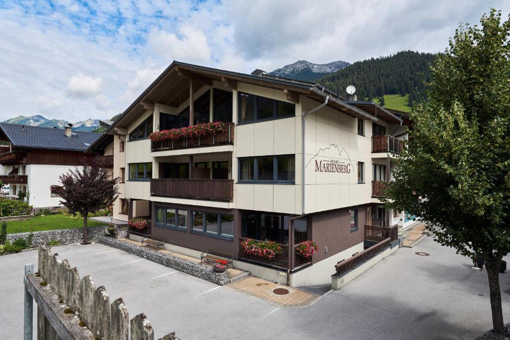 a hotel in the mountains with mountains in the background at Apart Marienberg in Lermoos
