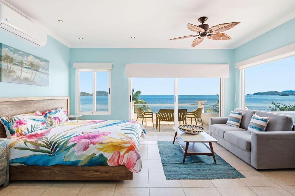 a bedroom with a bed and a couch at Beachfront Penthouse with Panoramic Ocean Views in Playa Flamingo