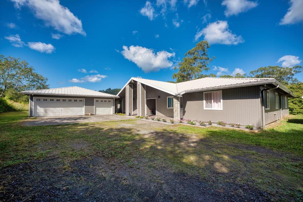 a house with a garage and a driveway at Hale Kululoa in Hilo