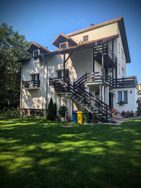a white house with stairs and a grass yard at Pokoje Gościnne Kalina in Łagów