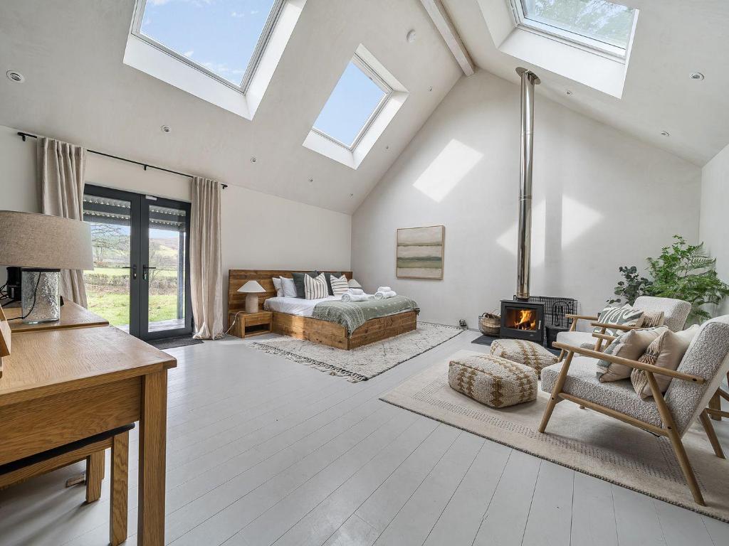 a living room with a bed and a fireplace at Grove Cottage in Kington