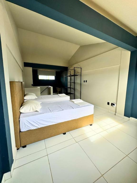 a bedroom with a large bed with a blue wall at City Studios Apartamentos Novos em Natal in Natal