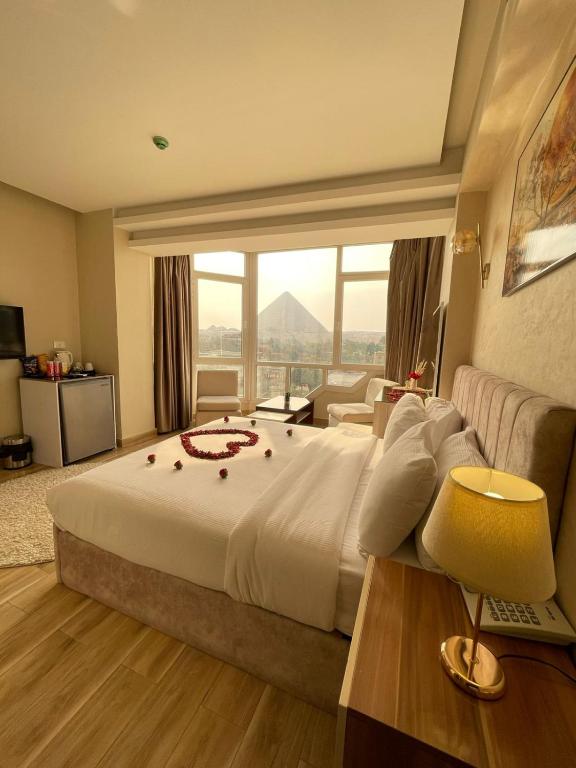 a bedroom with a large bed with a large window at Wonders Pyramids Hotel in Cairo