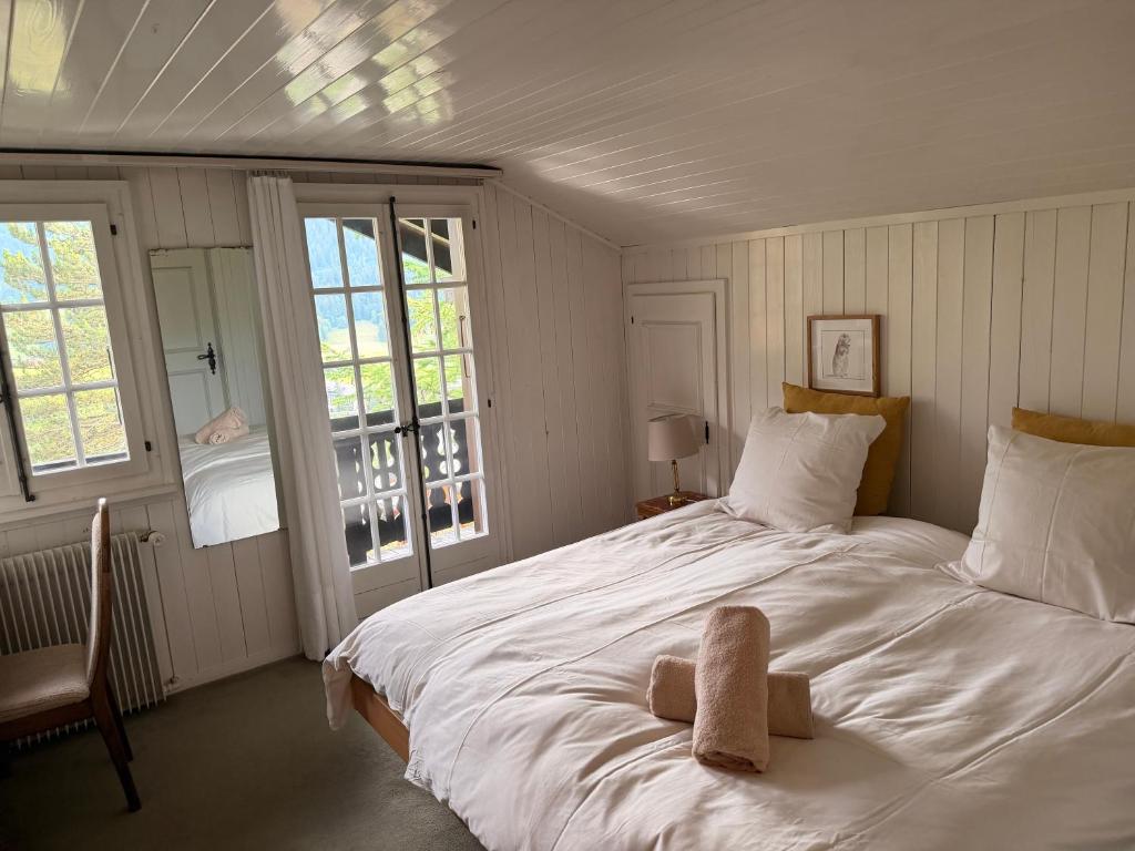 a bedroom with a bed with a stuffed animal on it at Cozy Le Lézard chalet with mountain view fireplace in Les Diablerets