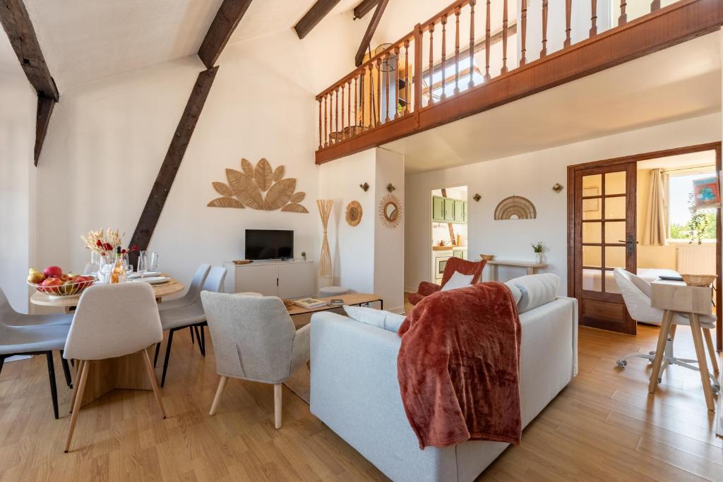 a dining room and living room with a table and chairs at Duplex de charme dans un Cloître historique Parking privé in Rouen