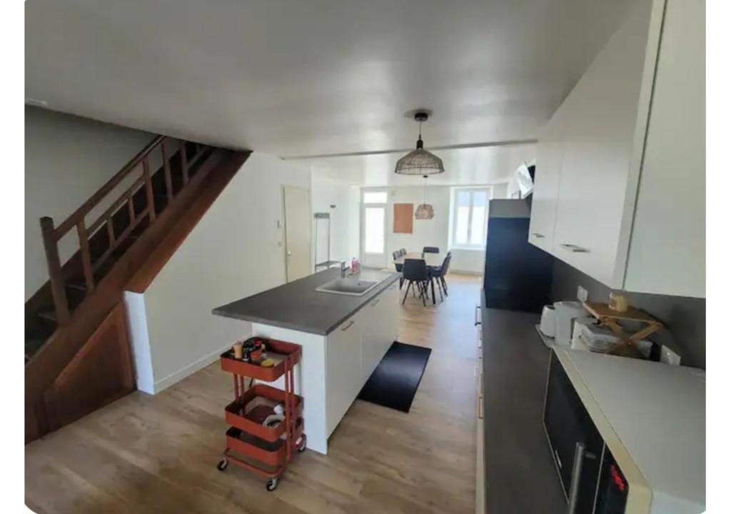 a kitchen and living room with a sink and a staircase at Le Petit Logis in Beaurepaire