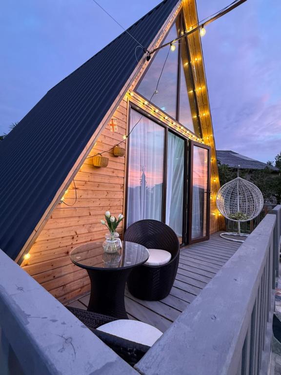 a house with a deck with a table and chairs at Cozy Home Buknari in Buknari