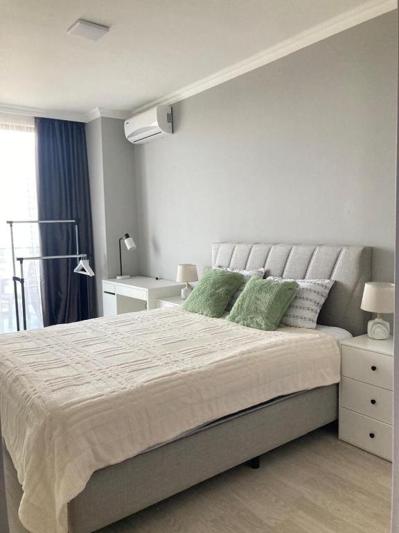 a bedroom with a large bed with green pillows at AL Mаre in Batumi