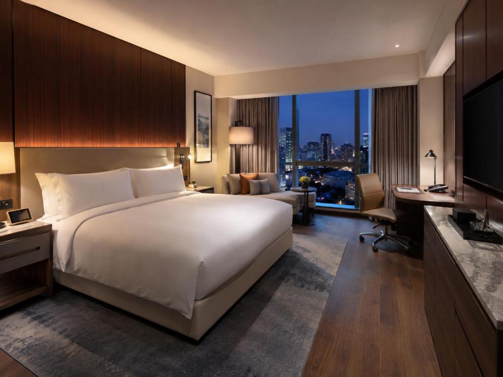 a hotel room with a large bed and a television at Hotel Platinum Square in New Delhi