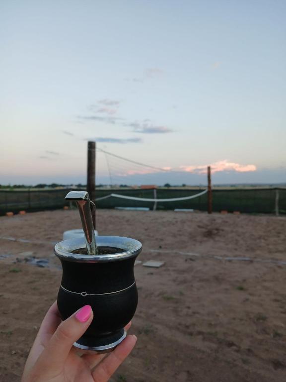 a hand holding a cup with a drink in it at Sudecada in Toay