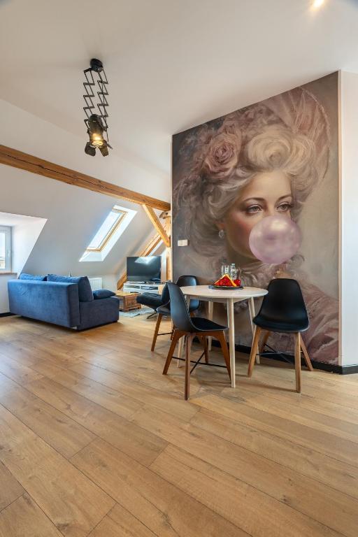 a living room with a large painting of a woman with a mask at Apartamenty Centrum - Sunshine in Opole