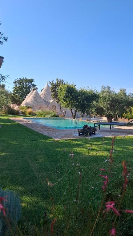 a park with a beach and some grass and some huts at Borgo dei trulli Fanelli in Castellana Grotte