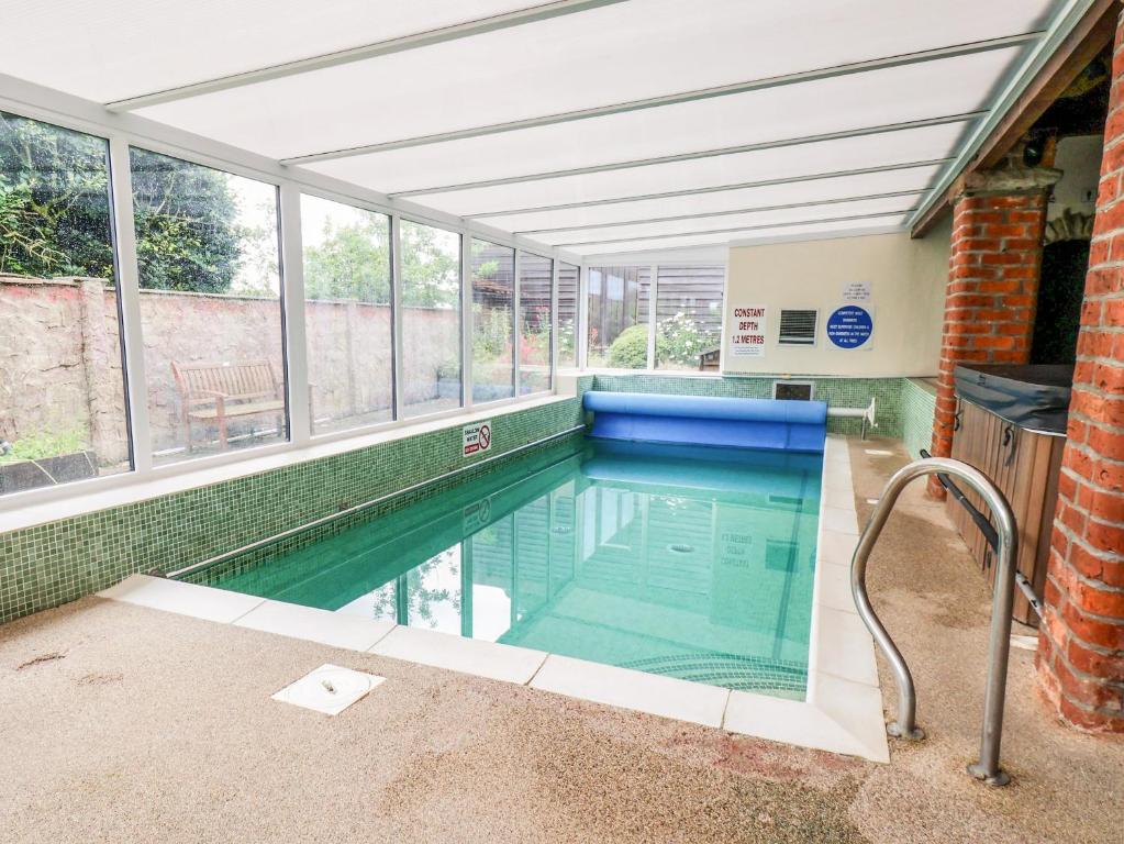 an indoor swimming pool in a building with windows at Granary in Pickering
