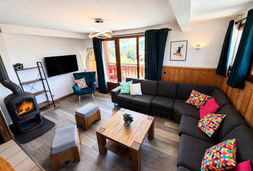a living room with a couch and a fireplace at Résidence Geffriand - Triplex pour 10 personnes proche des pistes au coeur des 3 Vallées MAE-4944 in Levassaix