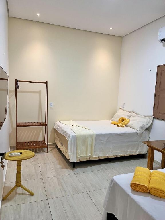 a room with two beds and a table and a mirror at Vila da Andrea in Barreirinhas