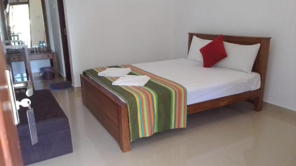 a small bed in a room with two boxes on it at Saruketha Cabana in Kegalle