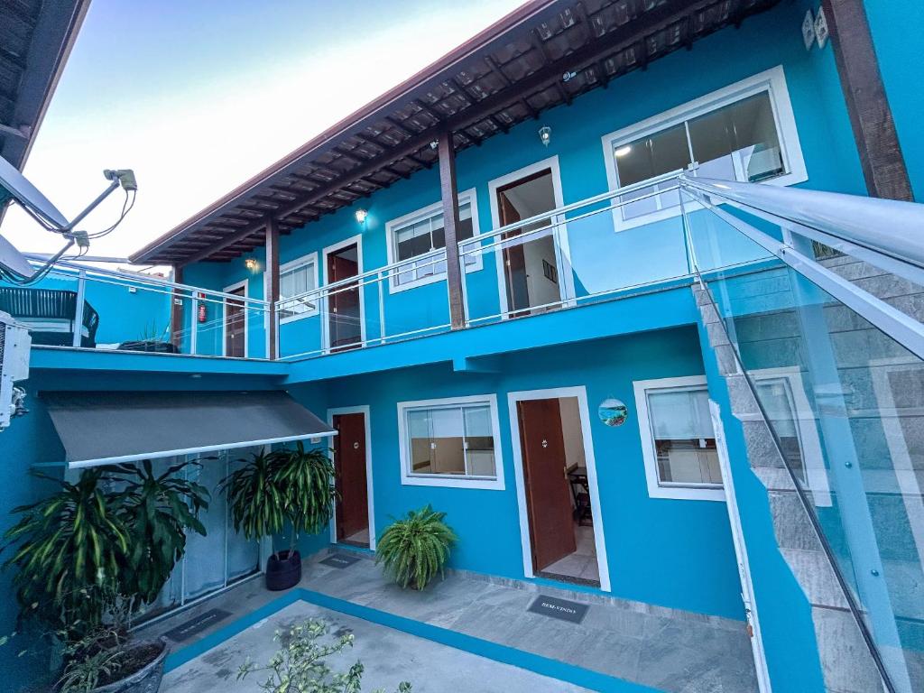 a blue house with a balcony and a staircase at Di Villa Búzios in Búzios