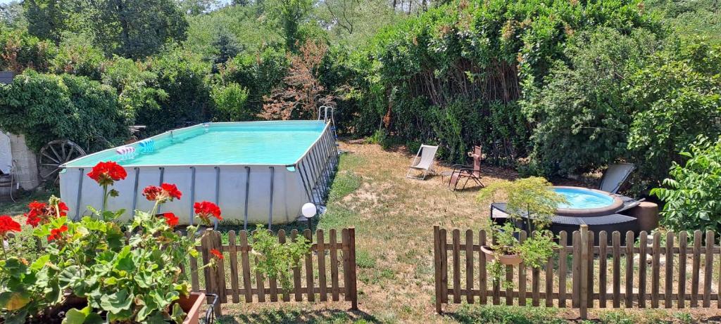 a swimming pool in a yard with a fence and flowers at Casa Bellotta in Suno