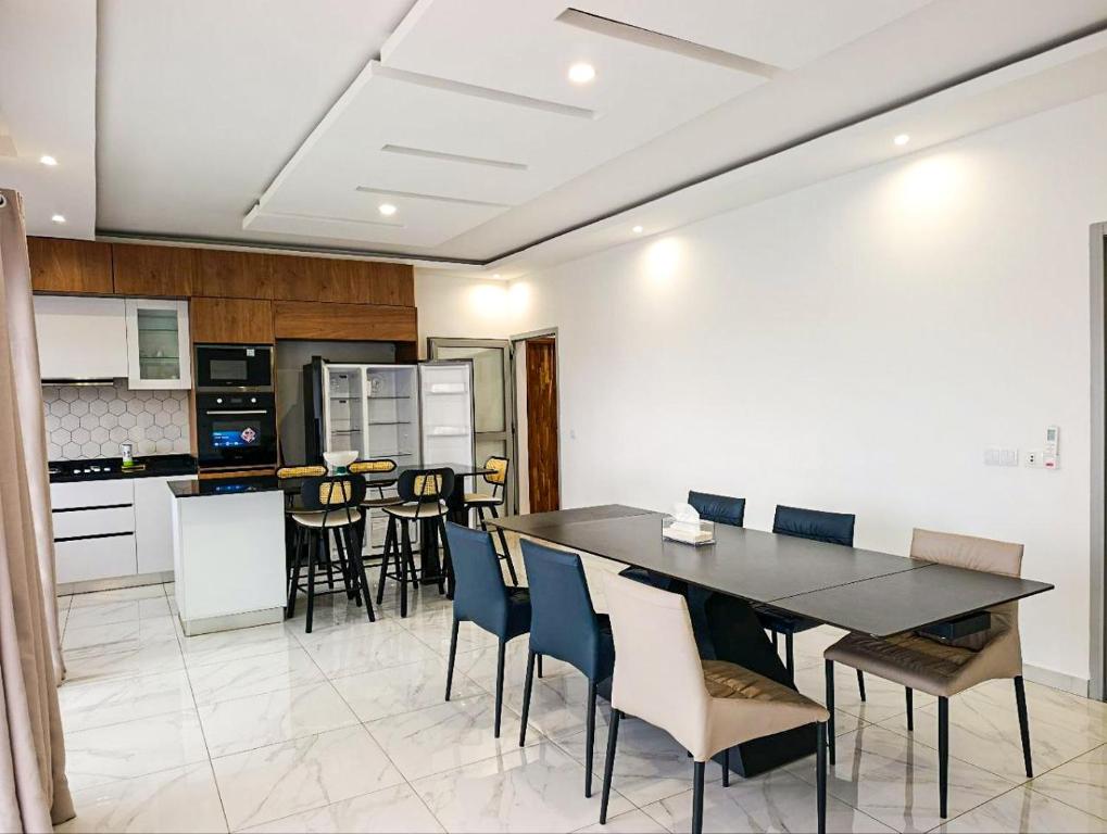 a kitchen and dining room with a table and chairs at Family House Assinie in Assinie