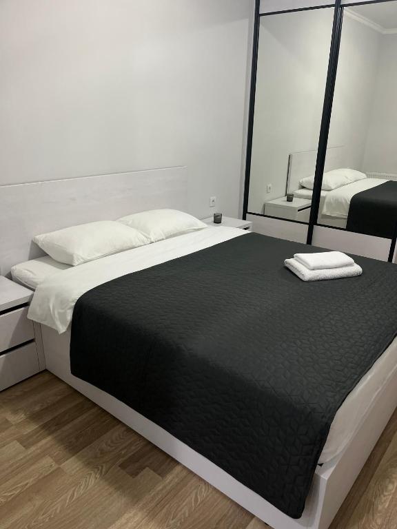 a bedroom with a large bed and a mirror at Apartament modern cu dormitor separat si balcon panoramic in Căuşeni