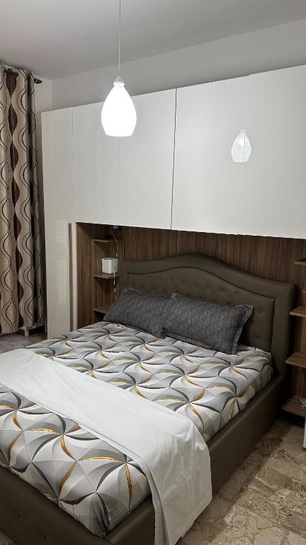 a bedroom with a large bed with white cabinets at Thind house in Brescia