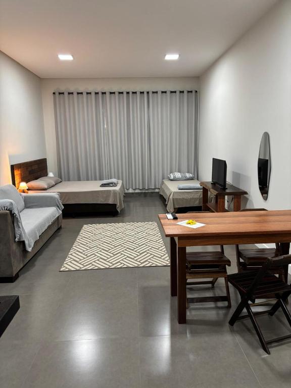 a living room with two beds and a table at Apartamento casa da Lu 102 in Primavera do Leste
