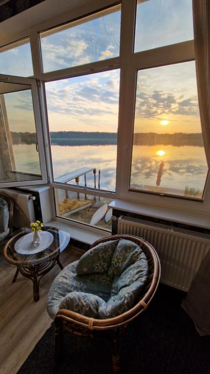 ein Zimmer mit einem großen Fenster mit Blick auf das Wasser in der Unterkunft Na Molo in Głębokie