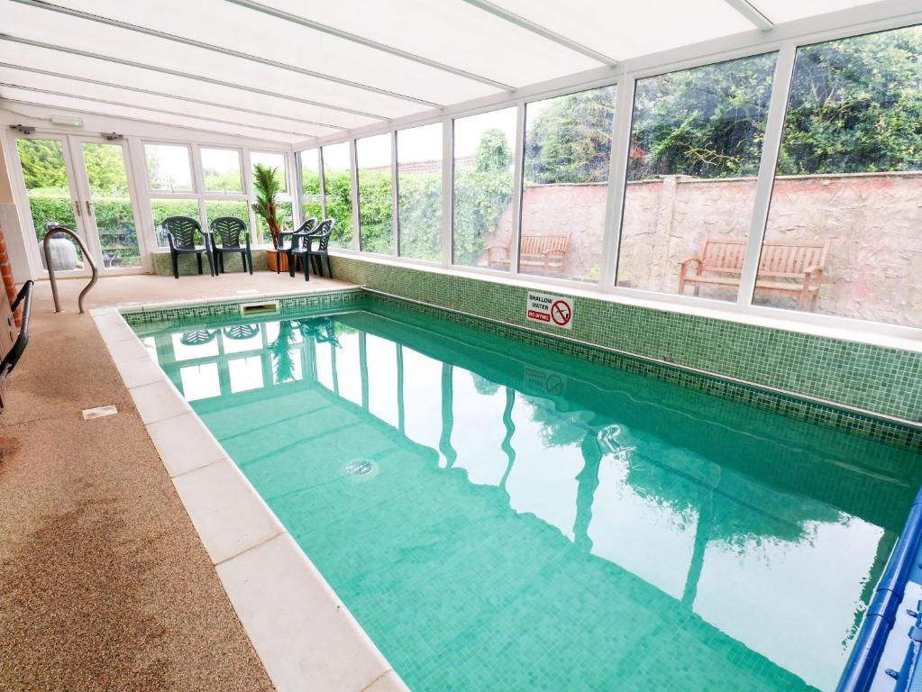 a swimming pool in a building with a large window at Owl in Pickering