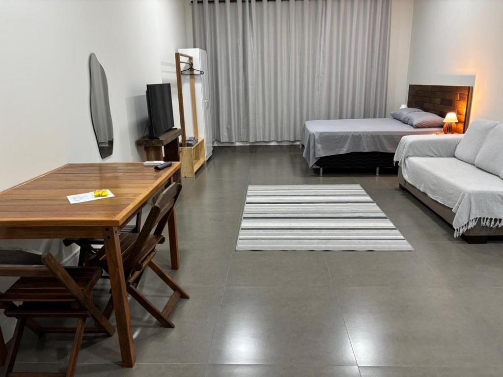 a living room with two beds and a table at Apartamentos casa da Lu 101 in Primavera do Leste