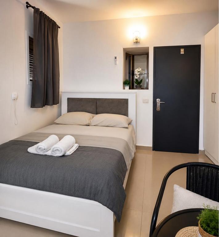 a bedroom with a bed with two white towels on it at יחידת נופש בעמק המעינות in Bet Sheʼan