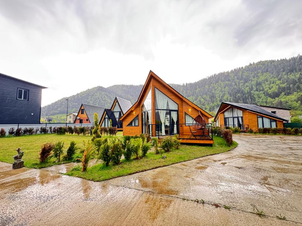 a large house with glass windows on a lot at Cottage Liantto in Borjomi