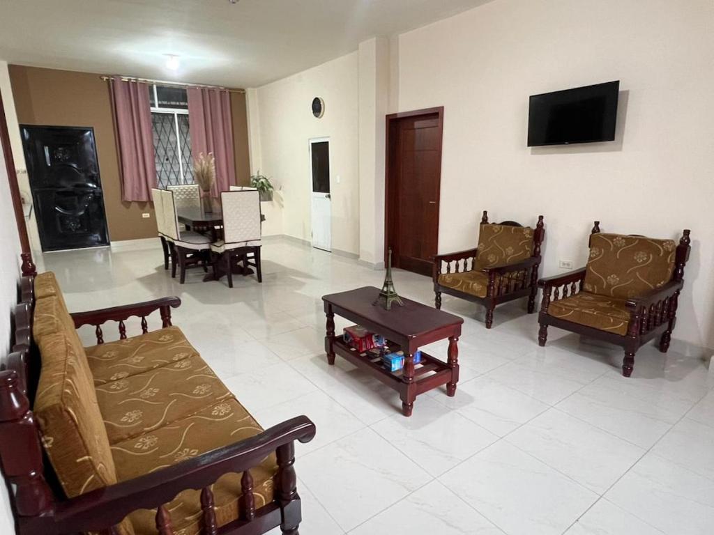 a living room with couches and chairs and a tv at Aruma House - Departamento de 2 Dormitorios in Tena
